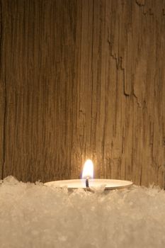 several candle in snow with wooden background
