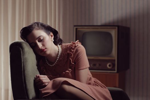 Young woman sleeping on armchair, 1950 styled 