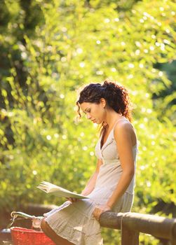 Young woman reading a book at a park