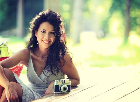 Portrait of young beautiful woman with vintage camera