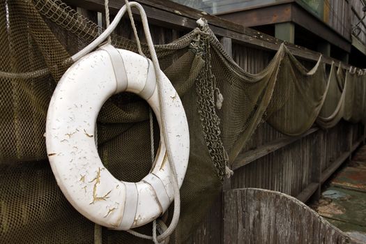 Old net and old lifebuoy are hanging on land