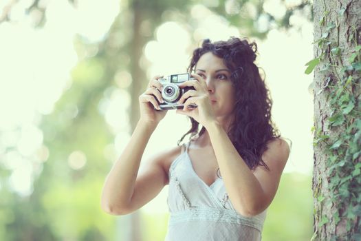 Portrait of an attractive young woman taking a photograph, focus on hand