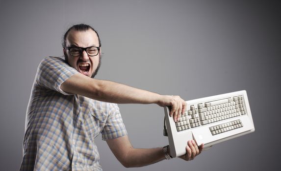 Angry man is destroying a keyboard
