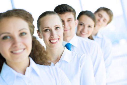 portrait of a young business woman standing in line with colleagues, concept of teamwork