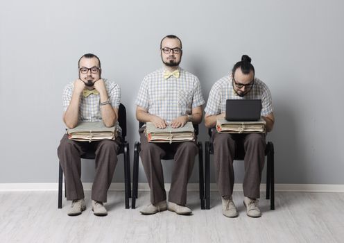 Conceptual image of three men waiting for an interview 