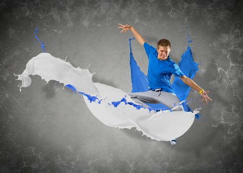 male dancer jumped surrounded by splashes of paint
