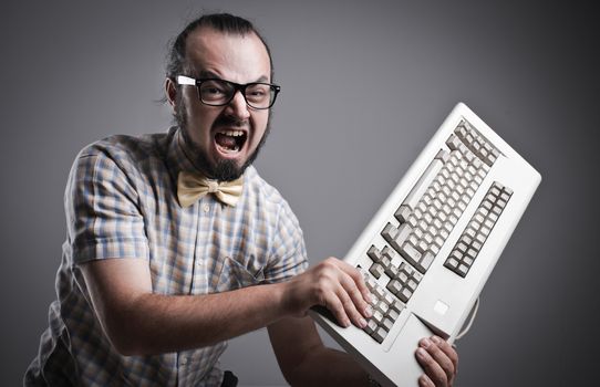 Angry man is destroying a keyboard