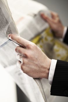 Businessman reading a newspaper, hand close up