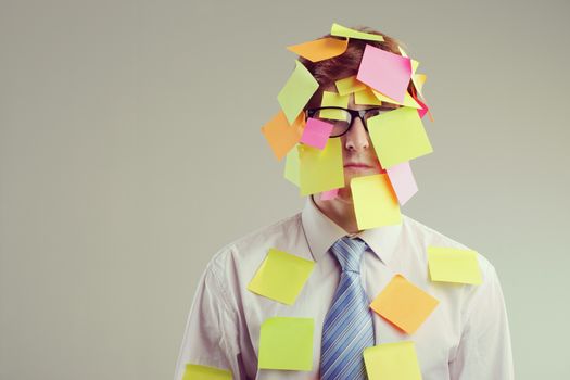 Office worker with post-its all over his face