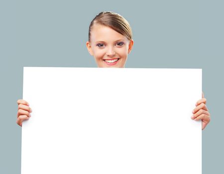 Happy blonde girl holding up a blank banner, copy space