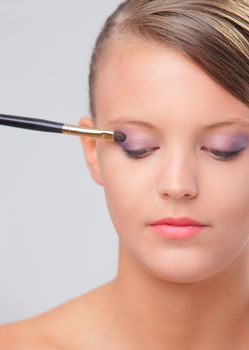 Portrait of beautiful fashion model applying professional makeup 