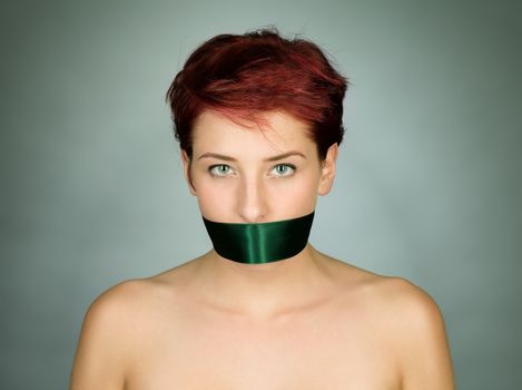 woman with her mouth bond with a green ribbon