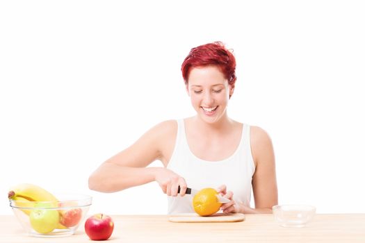 happy woman at breakfast cutting a orange on white background