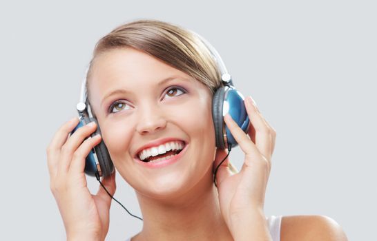 Pretty young woman listening to music on her headphones