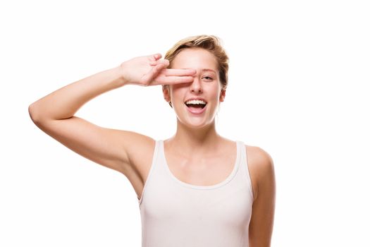 happy blonde woman holding two fingers over her eye on white background