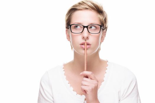 blonde young woman thinking with a pencil looking side up on white background