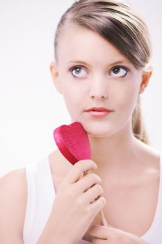 Teenager holding wooden heart in her hands 