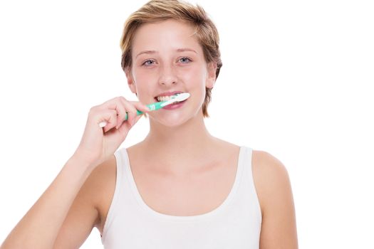 young blonde woman brushing her teeth with a toothbrush on white background