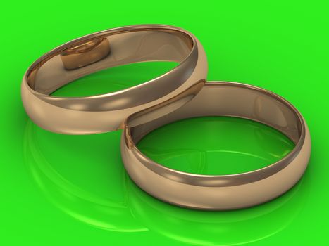 2 Gold wedding rings on a green background