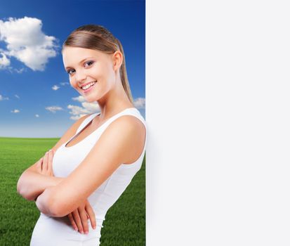 Attractive young woman leaning on a blank placard