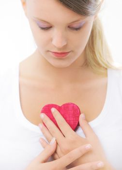 Teenager holding wooden heart in her hands 