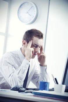 A stressed businessman sitting at office desk