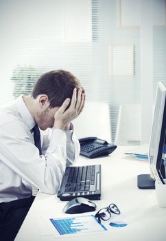 A worried businessman sitting at office desk