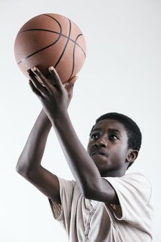 Boy concentrating to shoot a basketball on white background