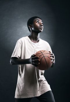 An African boy concentrating to shoot a basketball