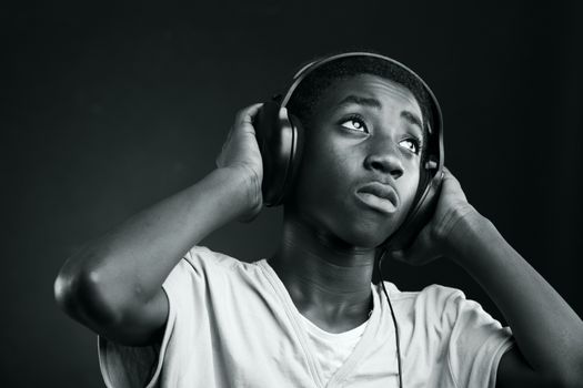 Portrait of african teenage listening music with headphones.