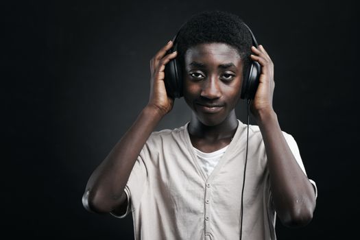 Portrait of african teenage listening music with headphones.