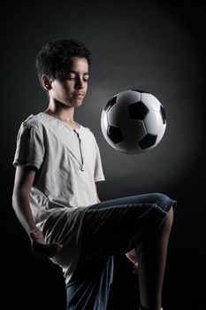 Portrait of young boy palying with a soccerball