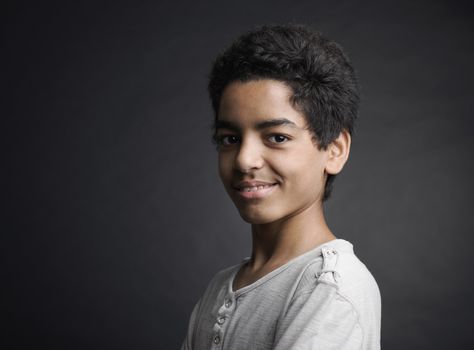 Portrait of cheerful african teenager on black background