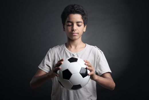 Portrait of young boy holding a soccer ball