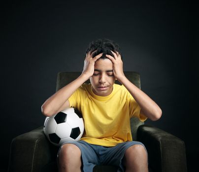 Brazilian soccer fans sitting on armchair and watching sport on TV. Favorite team didn't win a match