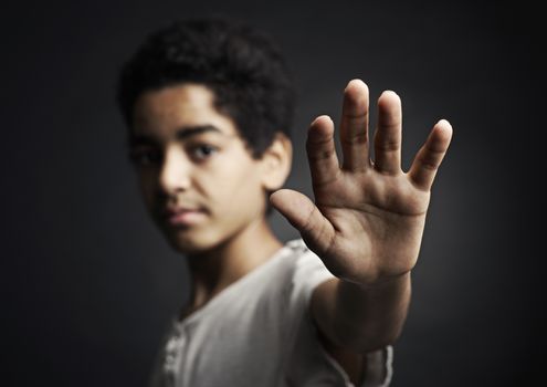 African teenager holds hand out as stop sign