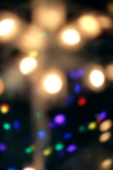 Christmas holiday lights on green tree as defocused background