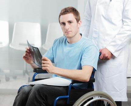 Male nurse pushing her disabled patient on a wheelchair. 