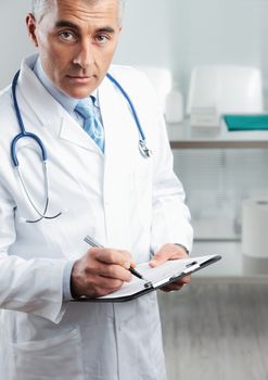 Cropped shot of a male doctor writing on clipboard 