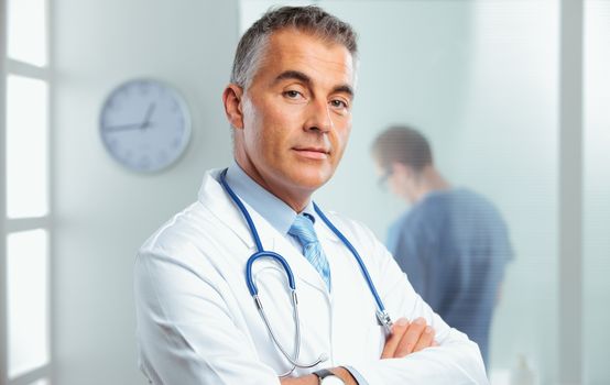 Portrait of a handsome male doctor, nurse on background