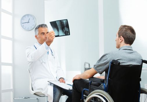 Young patient with mature doctor discussing x-ray