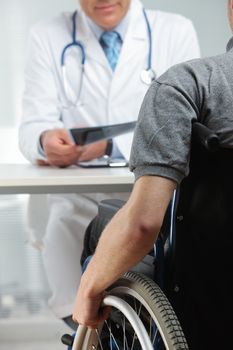 Young man on wheelchair meeting orthopedic doctor