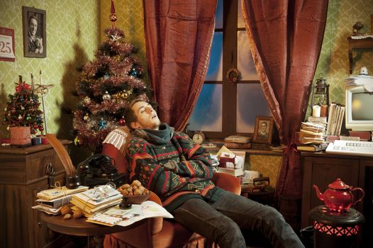 The son of Santa Claus sleeping  in an armchair on Christmas Day