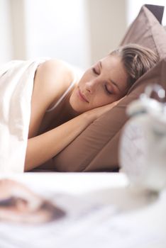 Young beautiful woman sleeping comfortably on bed