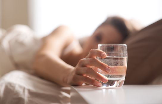 Close up of woman's hand taking a glass of water