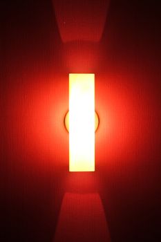 Tube of red neon light on textured wall