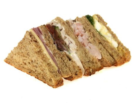 Selection of Cut Sandwiches on Brown Bread Isolated White Background