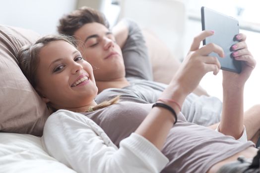 Young couple lying in bed using a digital tablet together 