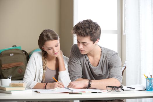 Teen boy and girl sitting together and studying 