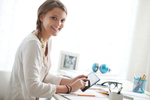 Portrait of a beautiful girl using digital tablet at home